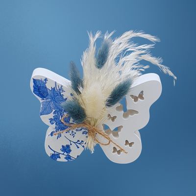Decoratieve opengewerkte vlinder van porseleingips met blauwe bloemen decoupage en droogboeketje