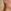 Fotorealistische close-up van rode druppelvormige oorbel van 63 mm hoog en 38 mm breed, gedragen door een blond muzikaal model met zilverkleurig oorhaakje.