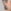 Close-up van een oor van een model met kort grijs haar dat een zwarte, ronde druppeloorbel draagt. De oorbel toont het silhouet van een Labrador in een cirkelvormig frame.