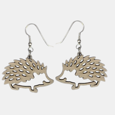 Handgemaakte-Houten-Egel-Oorbellen Set van twee lasergesneden houten egel oorbellen met gedetailleerde uitsparingen en zilverkleurige oorhaken, op een effen lichtgrijze achtergrond.