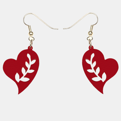 Detailopname Rode Hart Oorbel aan Zilverkleurige Haak Close-up van een rood, hartvormig oorbel met uitgesneden bladmotief, hangend aan een zilverkleurige oorhaakje in het oor van een vrouw met blond haar. Detailopname van de oorbel en het haar.