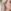 Fotorealistische close-up van een roze lint-oorbel aan een zilveren haakje, gedragen door een model met blond haar. Borstkanker bewustzijn juwelen.