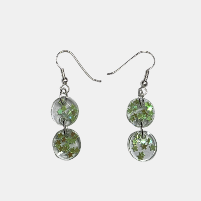 Handgemaakte transparante epoxy oorbellen bestaande uit twee verbonden cirkels gevuld met glanzende groene glitter sterretjes aan zilveren haken