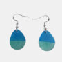 Druppelvormige Epoxy Oorbellen Blauw Groen Ocean Look Handgemaakte blauw-groene epoxy oorbellen in een verfijnde druppelvorm met een tweekleurig horizontaal kleurverloop en zilverkleurige haken.