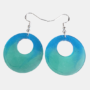 Handgemaakte ronde kunsthars oorbellen met een kleurverloop van oceaanblauw naar zeegroen en zilverkleurige haakjes.