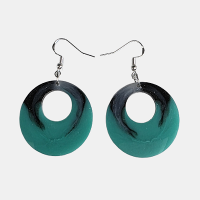 Handgemaakte ronde resin oorbellen met een organisch marmerpatroon in petrol groen en diepzwart voorzien van zilverkleurige haakjes.
