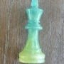 Limegroen-epoxy-koning-schaakstuk-handgemaakt. Close-up van een handgemaakt limegroen epoxy schaakstuk koning met subtiele glitters op een houten achtergrond.