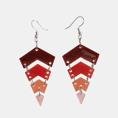 Handgemaakte glitter hars oorbellen in chevron vorm met een kleurverloop van donkerrood naar lichtroze aan zilverkleurige haakjes.