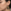 Gedetailleerde close-up van een vrouwelijk model met donker haar en een natuurlijke huid die een handgemaakte glitter hart oorbel draagt met een kleurverloop van transparant geel naar transparant zwart