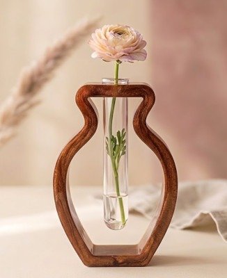 Houten Epoxy Propagation Vaas met Ranunculusbloem Een moderne epoxyvaas in de vorm van een fles met een glazen reageerbuis, gevuld met water en één roze ranunculusbloem en blad, geplaatst tegen een zachte achtergrond.