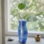 Blauwe Epoxy Stekjeshouder Modern Design Blauwe handgemaakte epoxy vaas met glazen reageerbuis voor stekjes op een houten vensterbank.